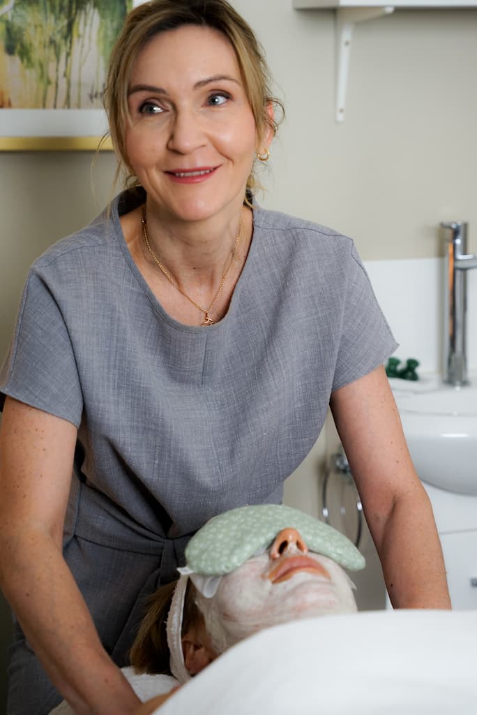 a Happy Dermatonics Clinic Partner providing a skincare facial with cream, facial mask and massage oils.
